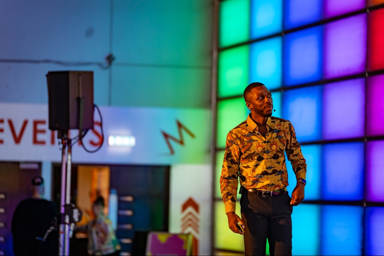 Washington at the Confidence Tour in Birmingham, in front of a wall of coloured light